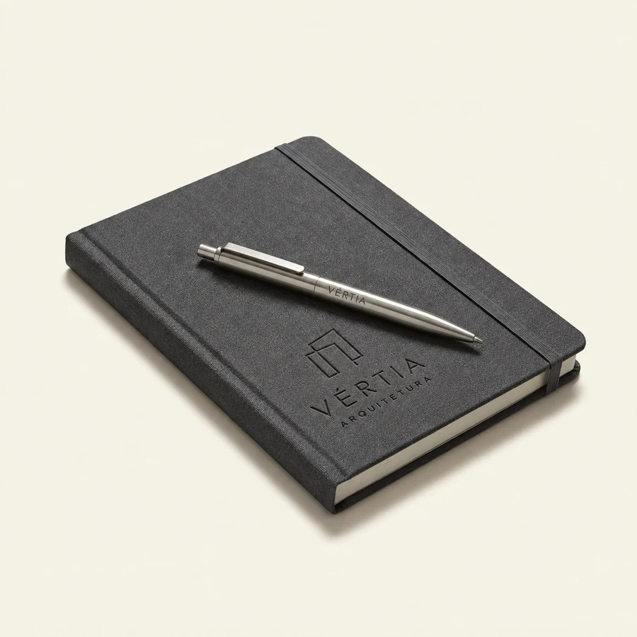 Caderno e caneta com a marca fictícia Vértia Arquitetura